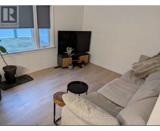 A living room with a couch, a table, and a television.