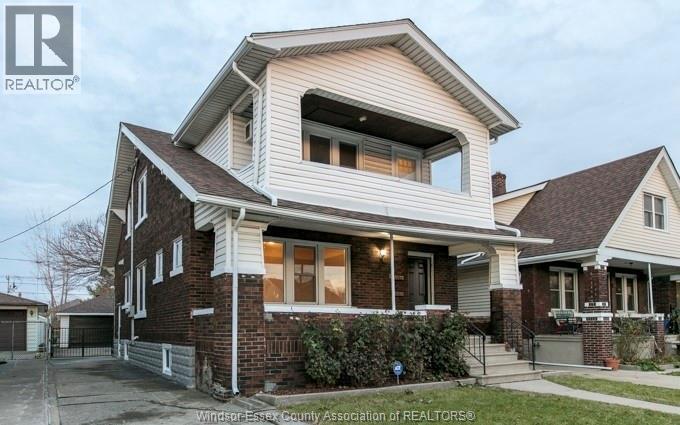A house with a brick facade and a large bay window is for sale.