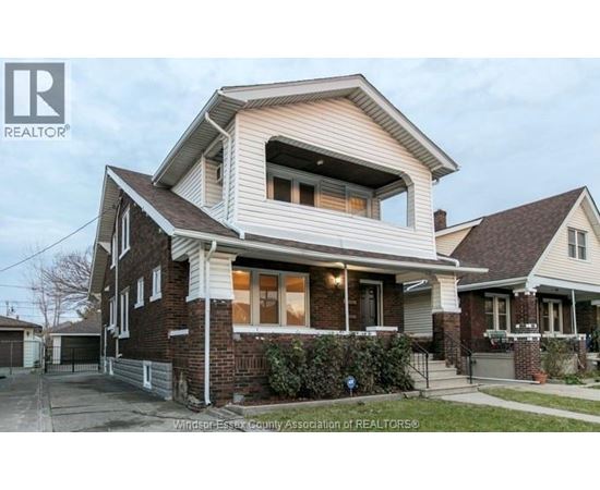 A house with a brick facade and a large bay window is for sale.