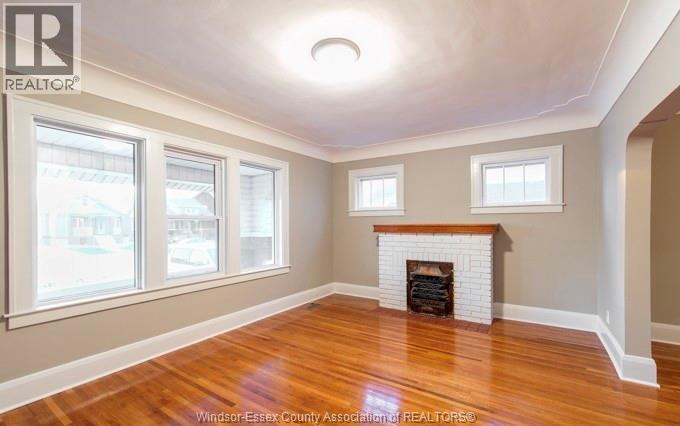 A room with a fireplace and wood flooring.