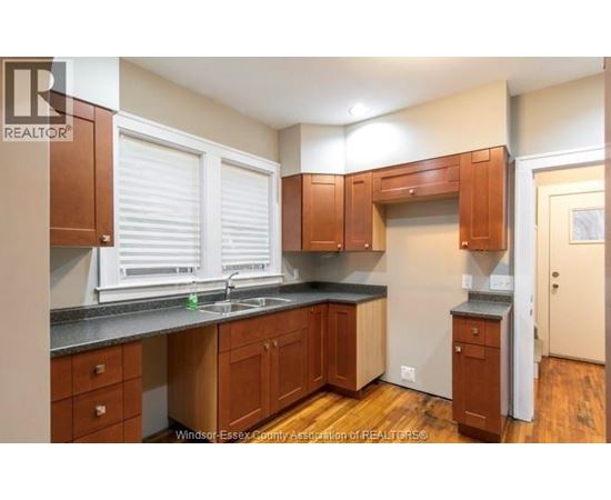 A kitchen with wooden cabinets and a black countertop.