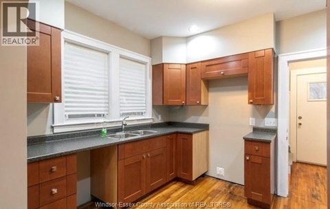 A kitchen with wooden cabinets and a black countertop.