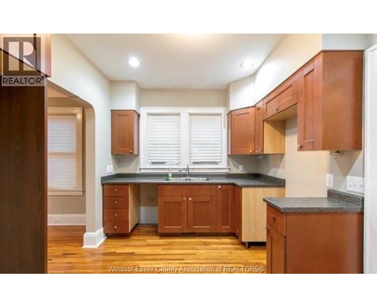 A kitchen with wooden cabinets and a granite countertop.