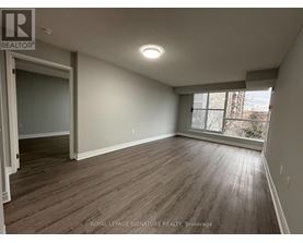 A room with wooden flooring and a window letting in light.