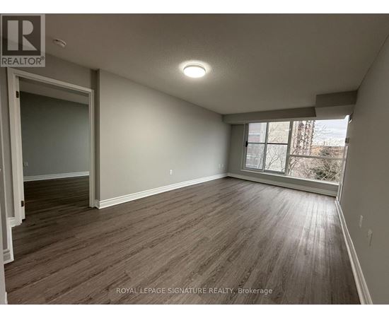 A room with wooden flooring and a window letting in light.