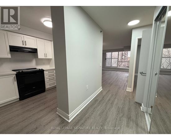 A kitchen area with a stove top oven and cabinets.