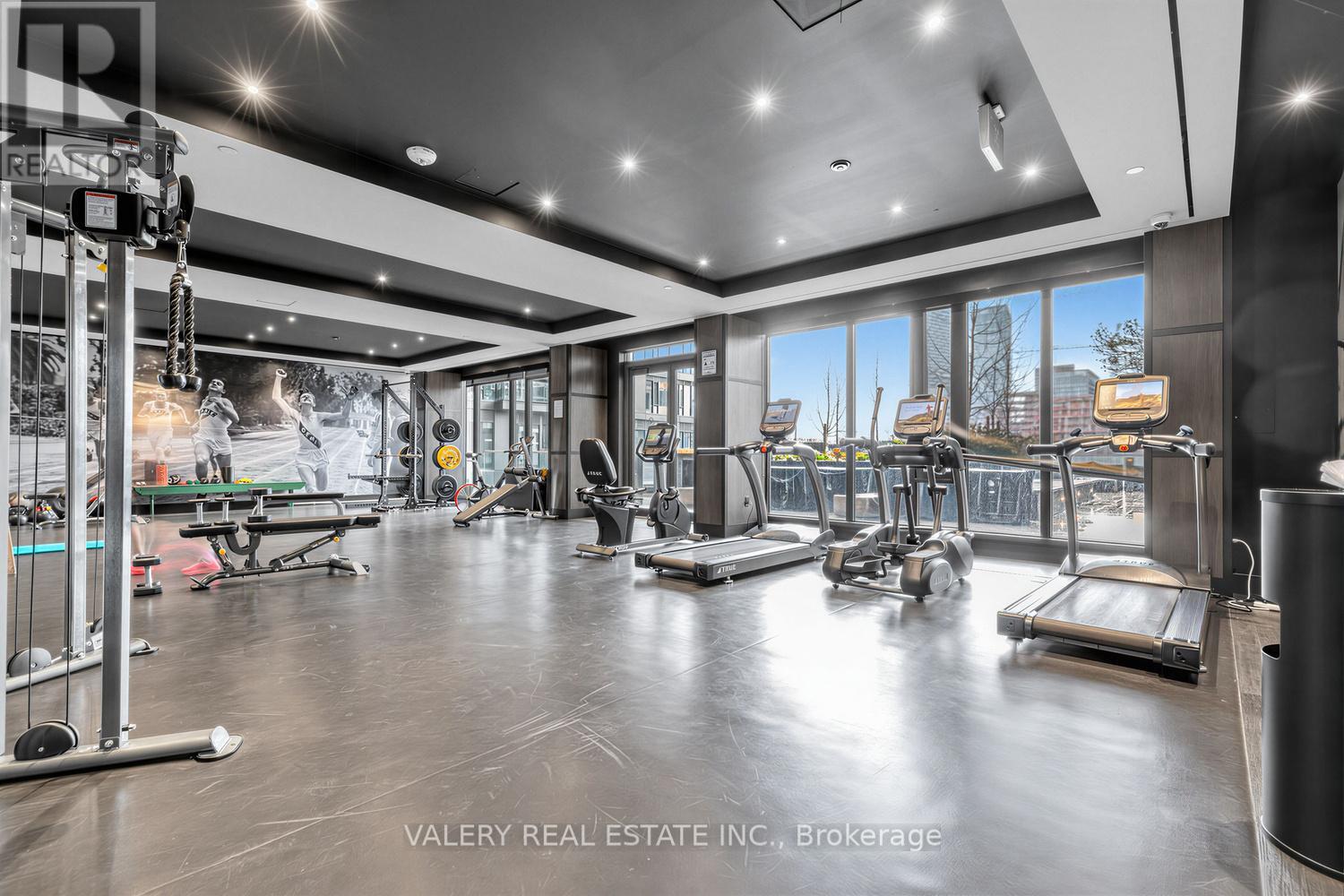 A gym with a variety of equipment including treadmills, weights, and exercise machines.