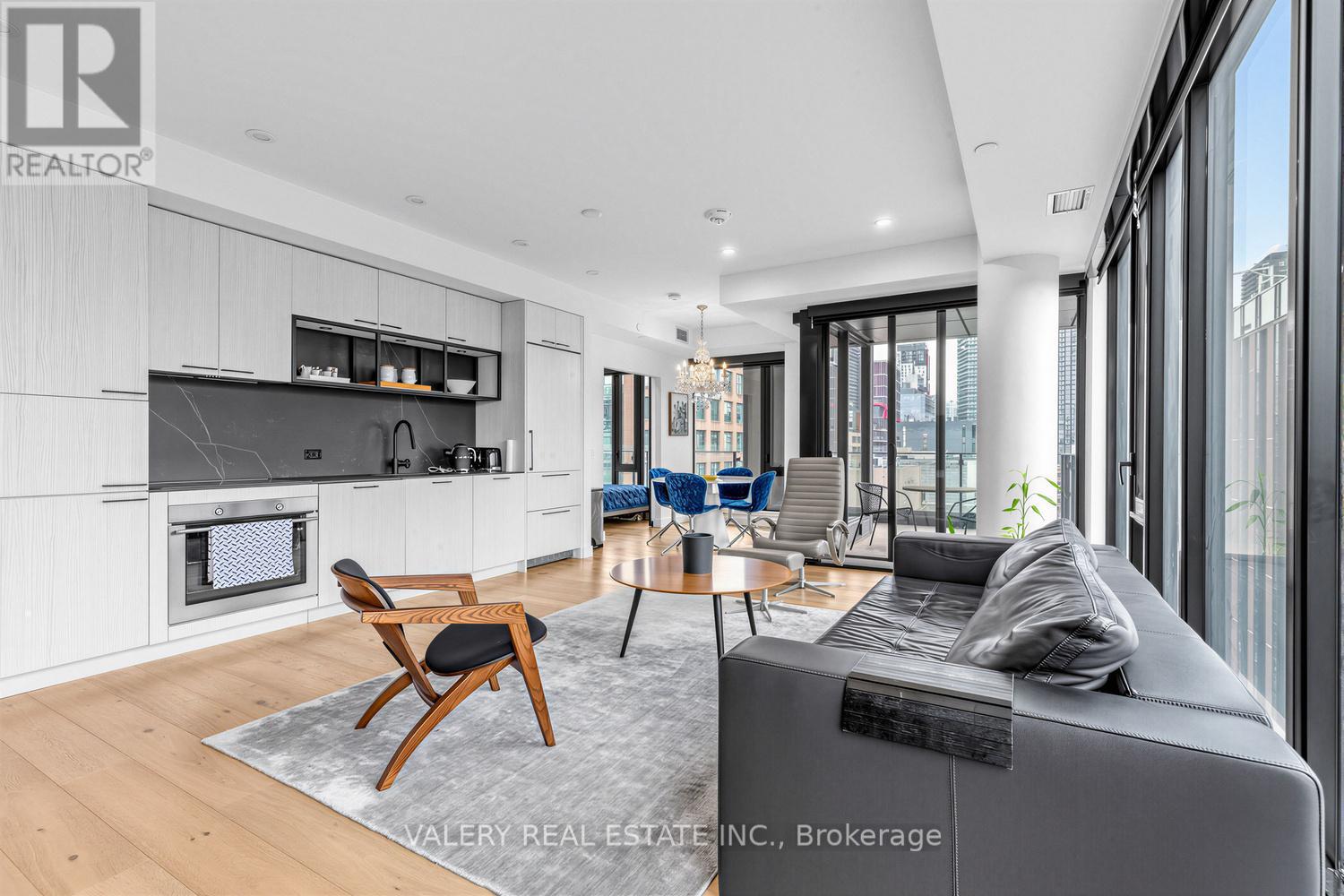 A modern living room with a grey sofa and a wooden chair.