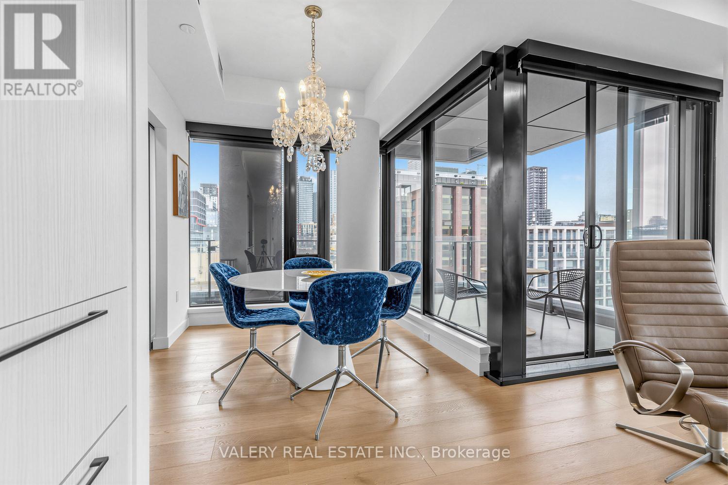 A dining room with a table and chairs and a chandelier.