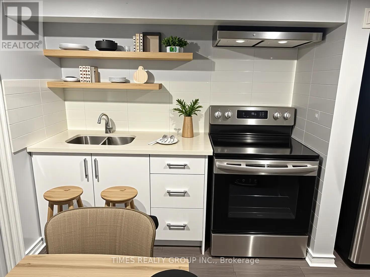 A modern kitchen with a stainless steel oven and white cabinets.