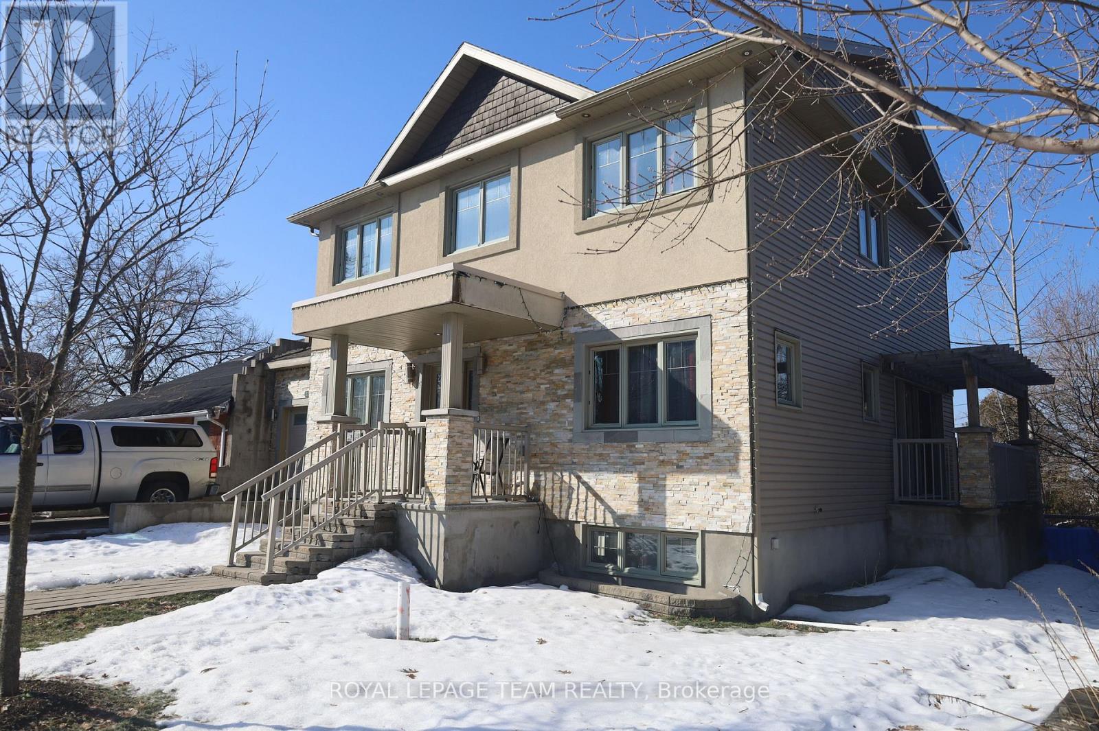 A two-story house with a garage and a car parked in front.