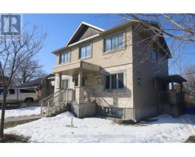 A two-story house with a garage and a car parked in front.