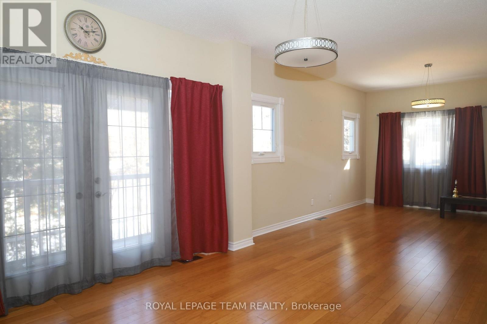 A room with wooden floors and red curtains.