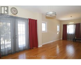 A room with wooden floors and red curtains.
