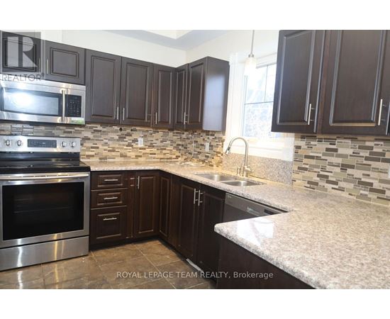 A kitchen with dark brown cabinets and a stainless steel oven.