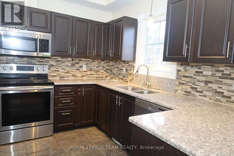A kitchen with dark brown cabinets and a stainless steel oven.