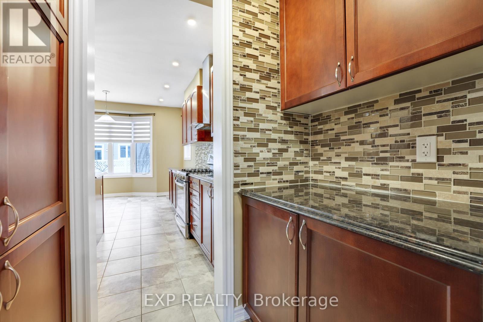 A kitchen with brown cabinets and a tiled backsplash.