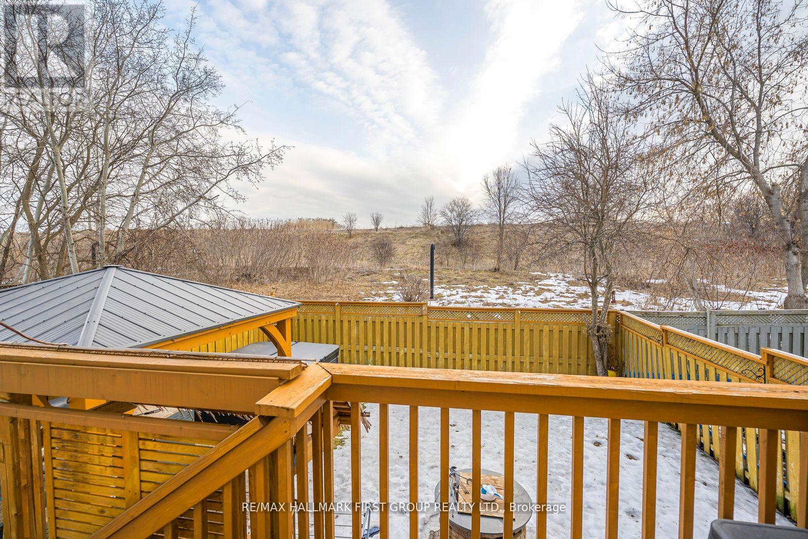 A snowy landscape with a wooden deck and a gazebo.