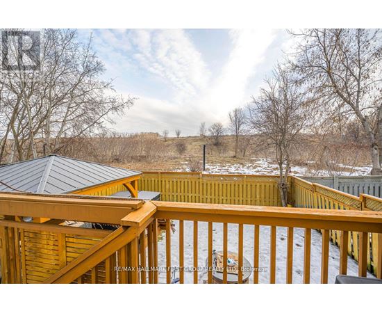 A snowy landscape with a wooden deck and a gazebo.