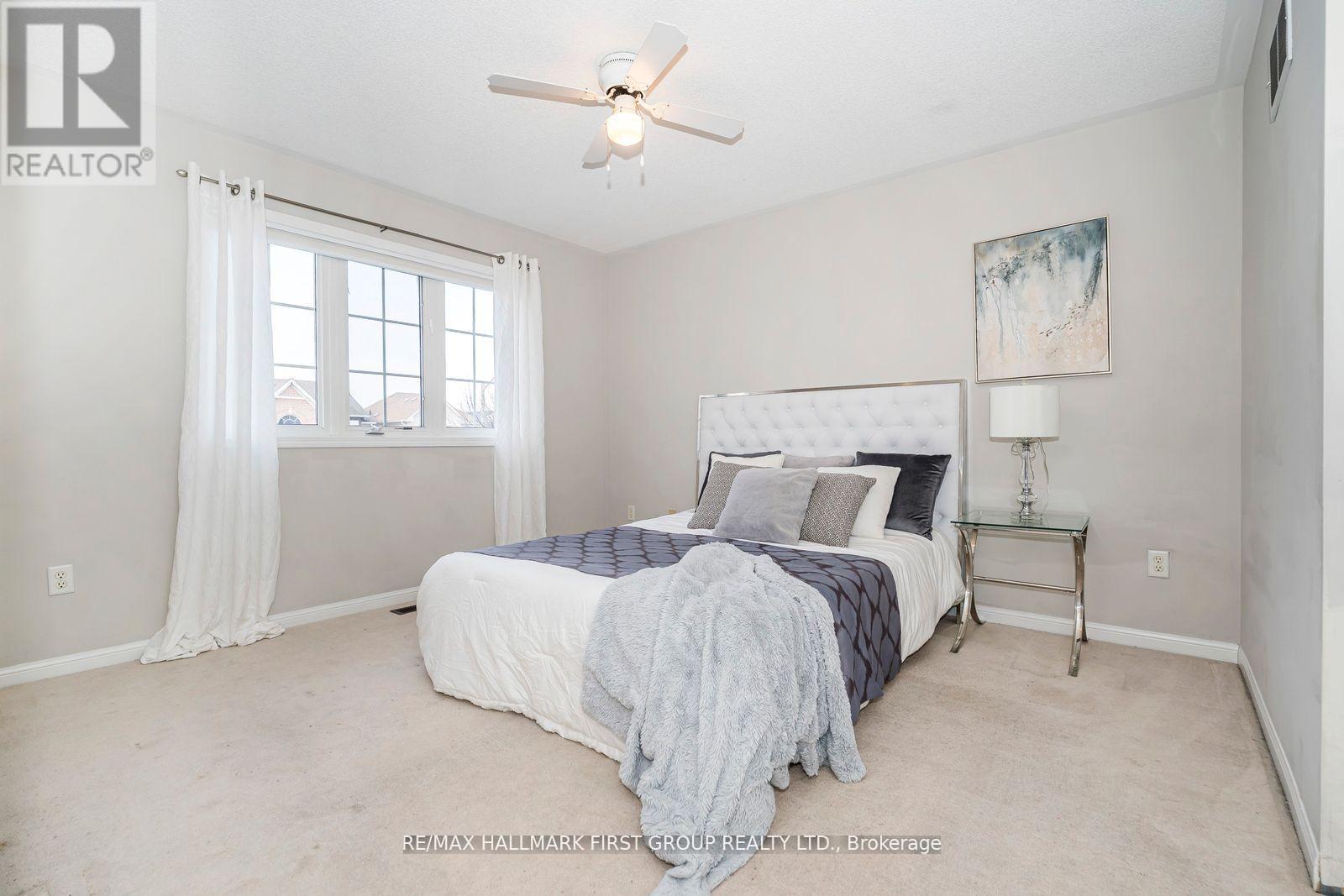 A bedroom with a bed, nightstand, and window.