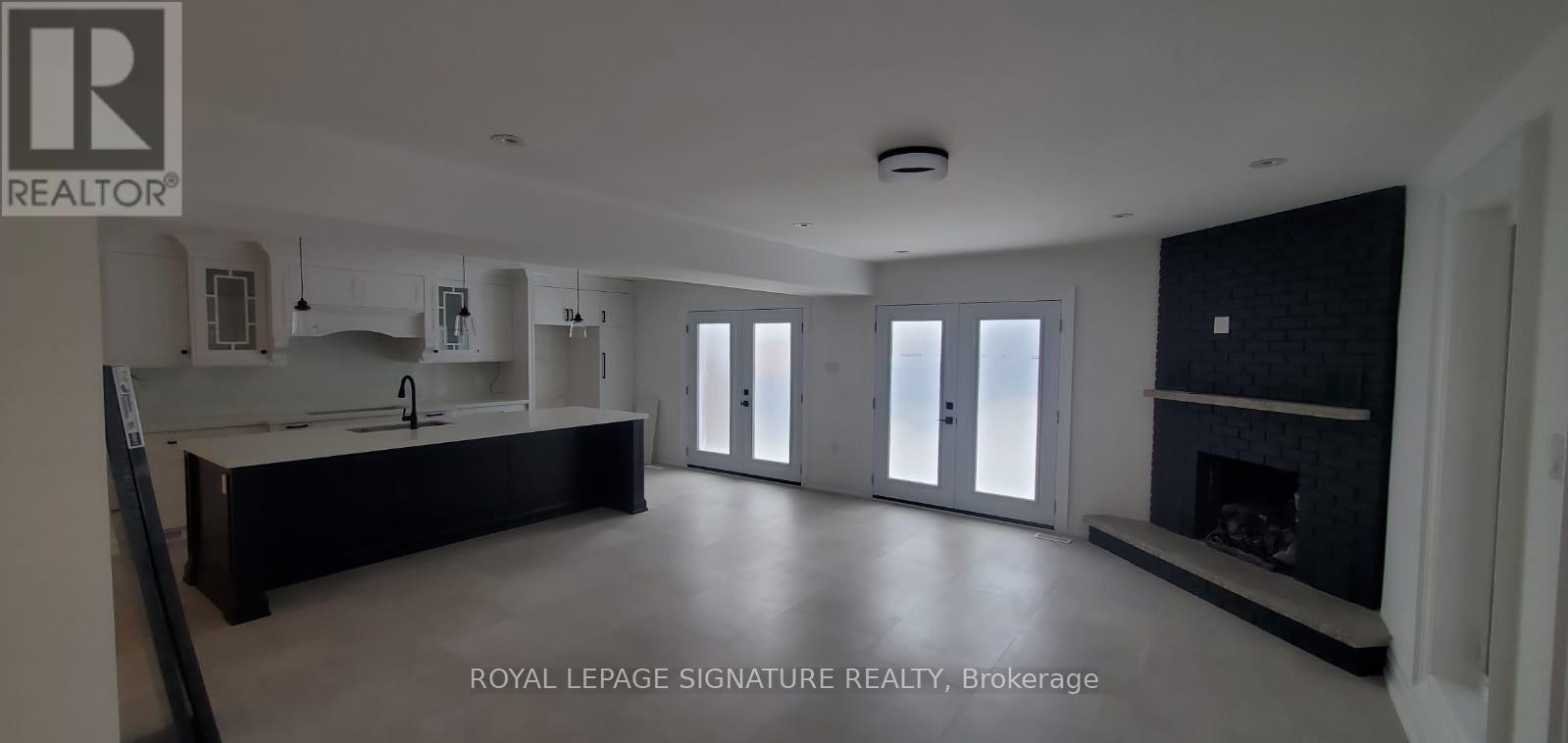A spacious living room with a fireplace and sliding glass doors.