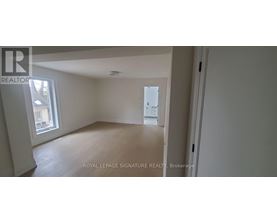 A white room with a window and a door leading to another room.