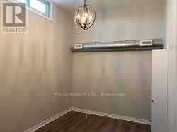 A room with a wooden floor and a light fixture on the wall.