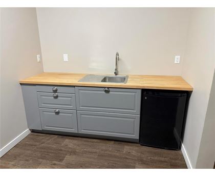 A kitchen with a sink and a trash can.