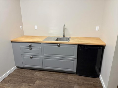 A kitchen with a sink and a trash can.