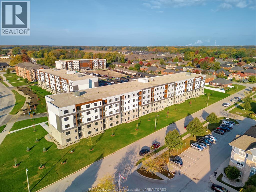 An aerial view of a large apartment complex with a parking lot in front.