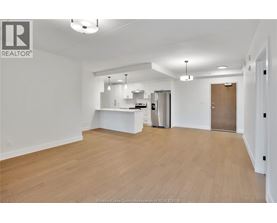 A spacious, empty room with wooden flooring and white walls.