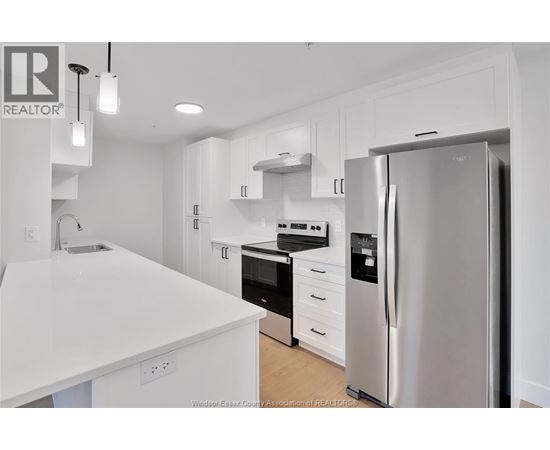A modern kitchen with white appliances and cabinets.