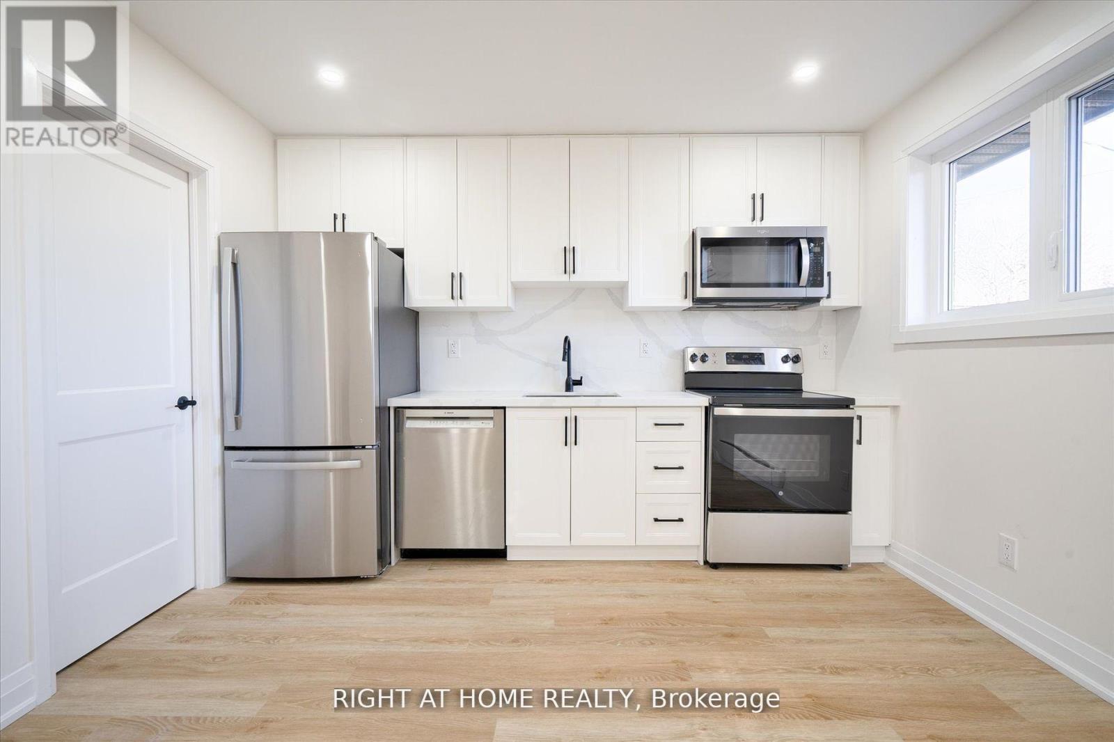 A kitchen with white cabinets and stainless steel appliances.