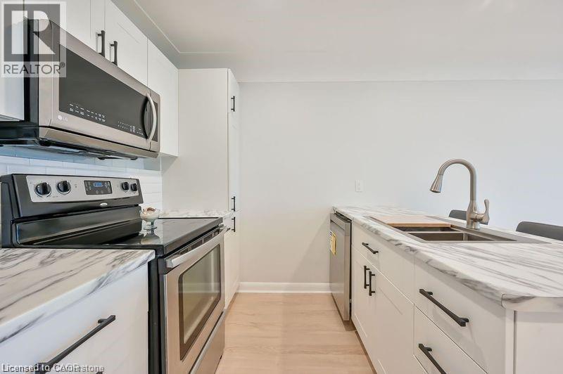 A kitchen with a stove, oven, and sink.