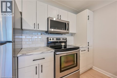 A kitchen with white cabinets and a black stove top.