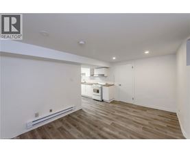 A well-lit kitchen with wooden floors and white walls.