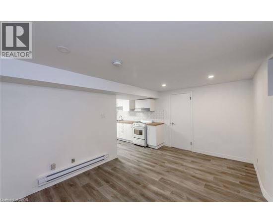 A well-lit kitchen with wooden floors and white walls.