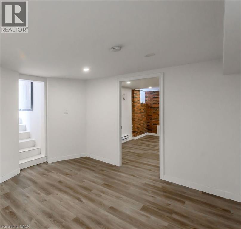 A room with wooden flooring and white walls.
