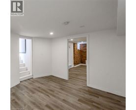 A room with wooden flooring and white walls.