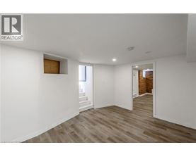 A spacious room with wooden flooring and white walls.