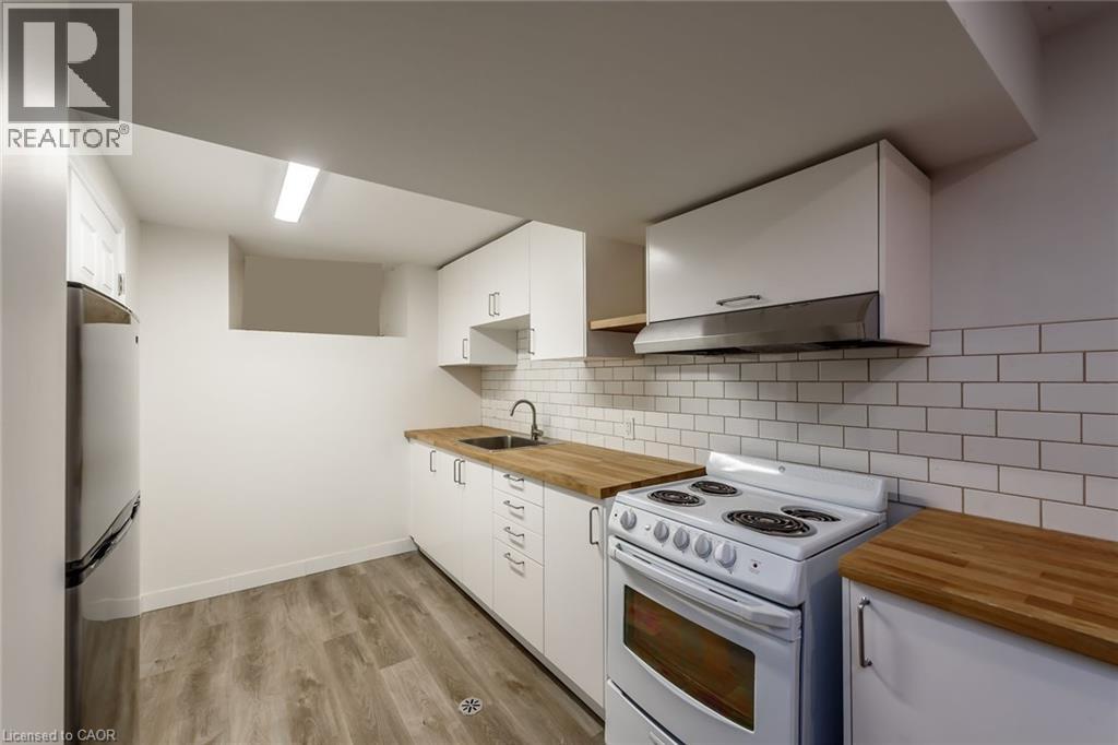 A kitchen with white cabinets and a white stove top oven.