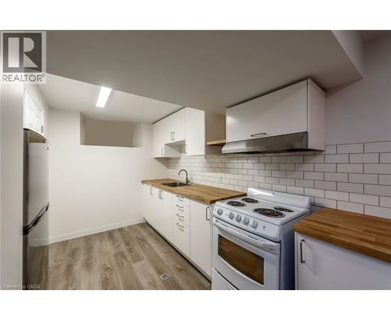 A kitchen with white cabinets and a white stove top oven.