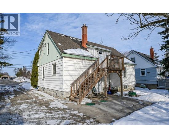 A house with a wooden staircase leading to a covered entrance.