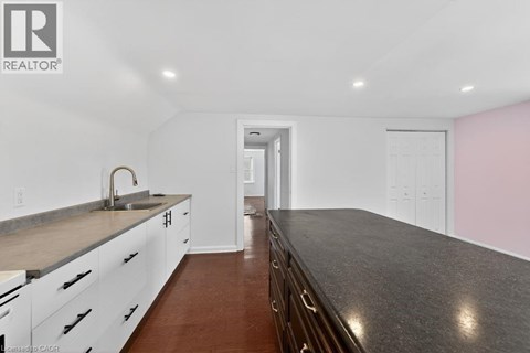 A modern kitchen with white cabinets and a dark countertop.