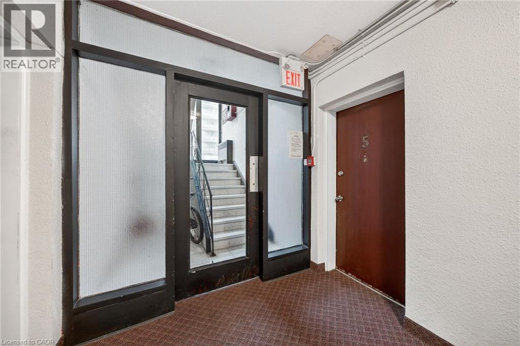 A hallway with a door and a window with a sign that says exit.