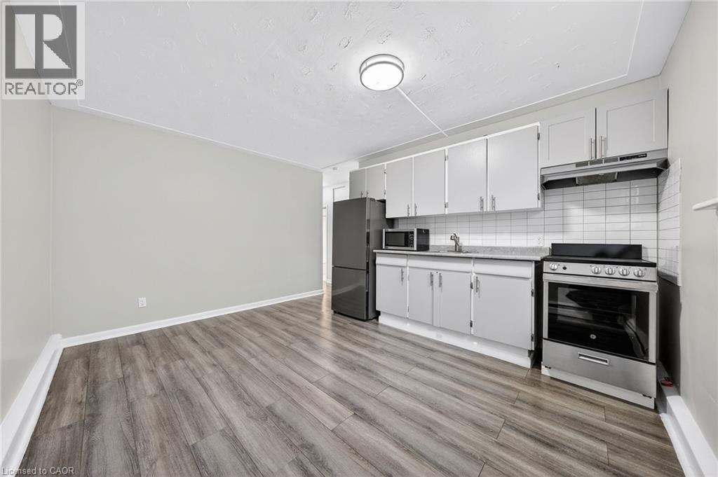 A kitchen with a stove top oven and a refrigerator.