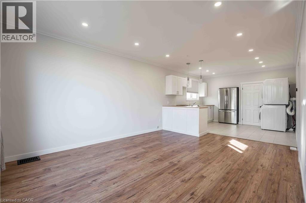A spacious room with wooden flooring and white walls.