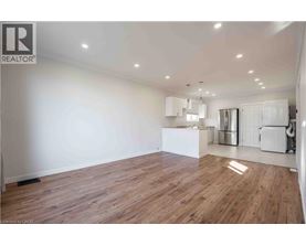 A spacious room with wooden flooring and white walls.
