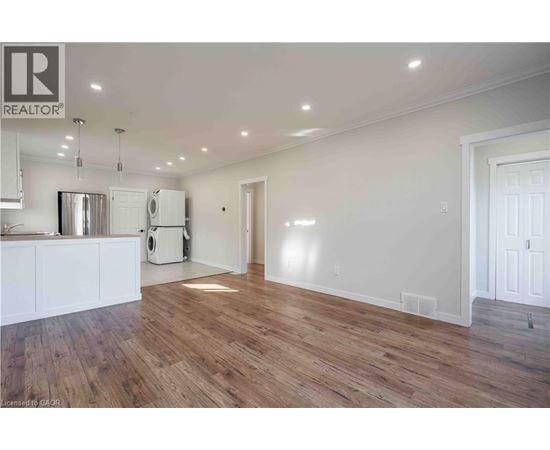A large empty room with wooden floors and white walls.
