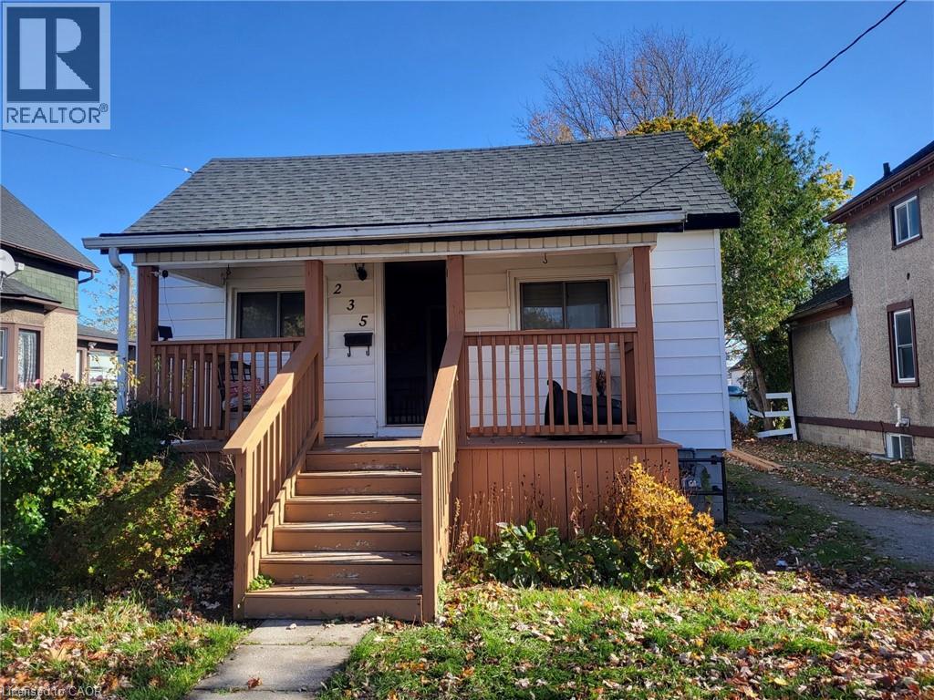A small white house with a brown front porch.